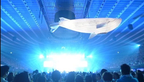 会場上空を泳ぐクジラのバルーンと青い照明